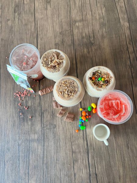 A group of bowls with different kinds of desserts on a wooden table.