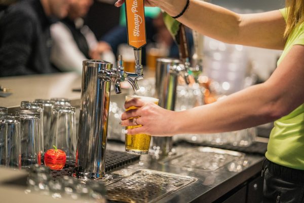 A woman pouring a beer at a bar.