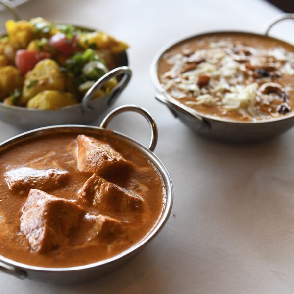 Three bowls of food on a table.