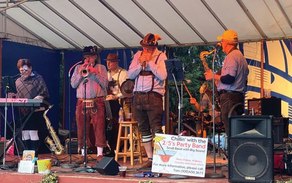 A group of musicians on stage at an outdoor event.