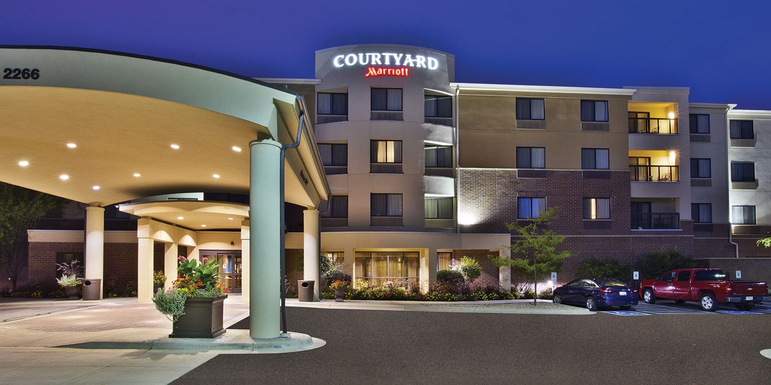 a hotel at night with cars parked in front of it