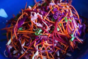 a blue bowl filled with lots of veggies