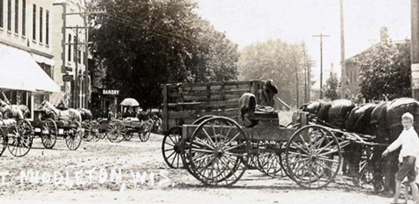 a black and white photo of a horse drawn carriage