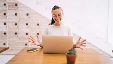 joyful woman with computer creating graphic design for website connecting to WIFI