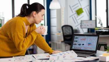 Image showing a business woman looking at various membership site statistics on her laptop.