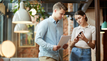 An image shows two business partners analyzing the results of their recent mobile app marketing strategy.