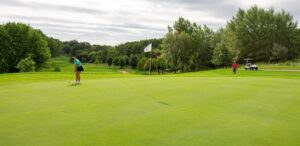 two people playing golf on a golf course